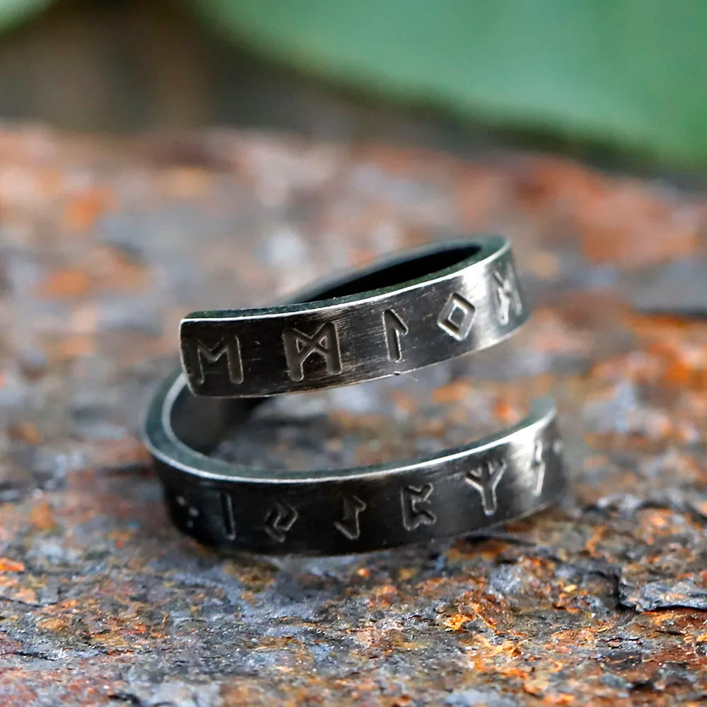Two silver rings with engraved symbols on a textured surface Viking ring with Norse motifs