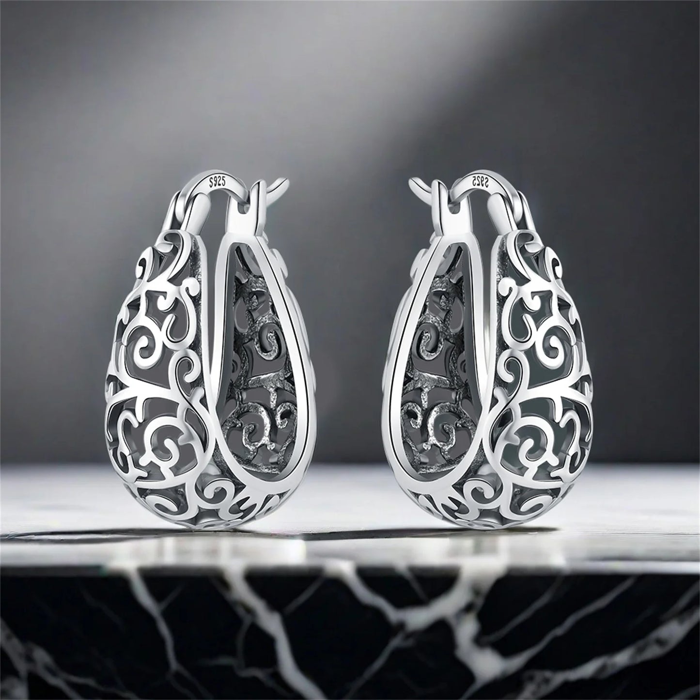 Side angle of 925 sterling silver vine hoop earrings under studio lighting