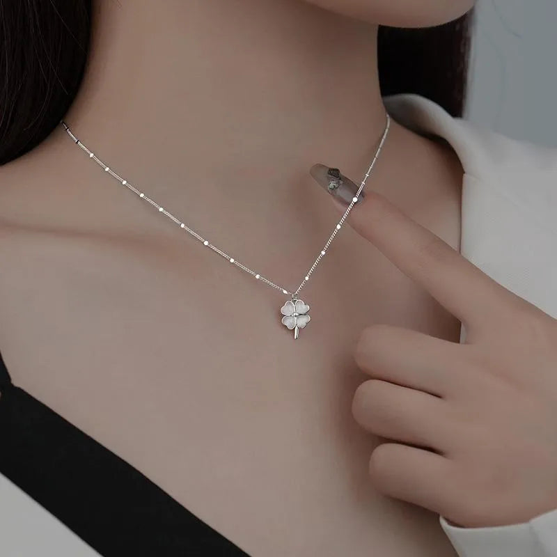 Elegant sterling silver four-leaf clover pendant necklace worn by woman