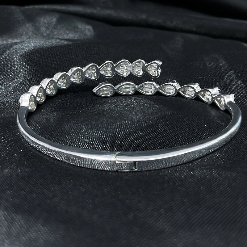 Top view of sterling silver zircon bangle in open cuff design on black background
