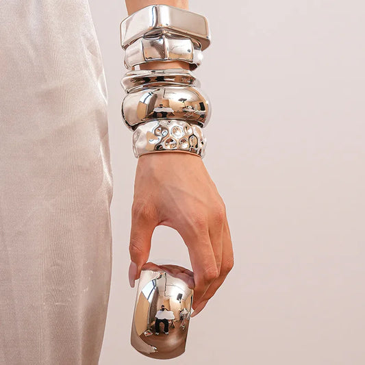 High-shine silver alloy cuff bracelets in geometric and bubble designs, stacked fashion look