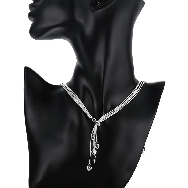 Silver layered necklace with teardrop crystal charms showcased on black mannequin bust