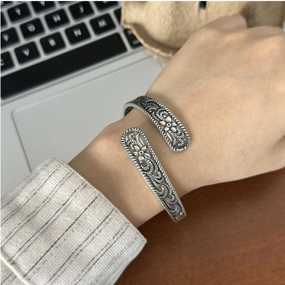 Unisex silver-plated vintage floral cuff bracelet on wrist, antique oxidized finish