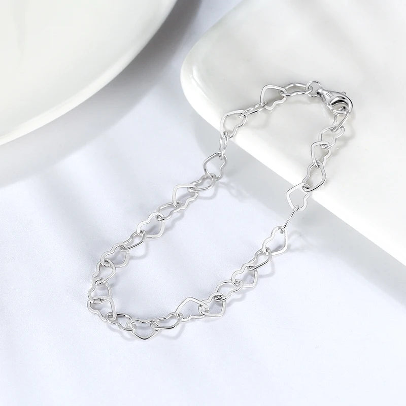 Elegant 925 sterling silver bracelet with delicate heart-shaped links, rhodium plated for extra shine and tarnish protection.