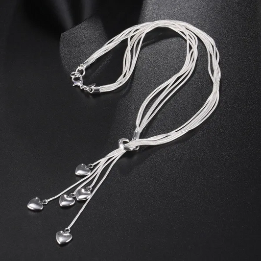 Multi-strand sterling silver necklace with teardrop crystal charms displayed on black fabric
