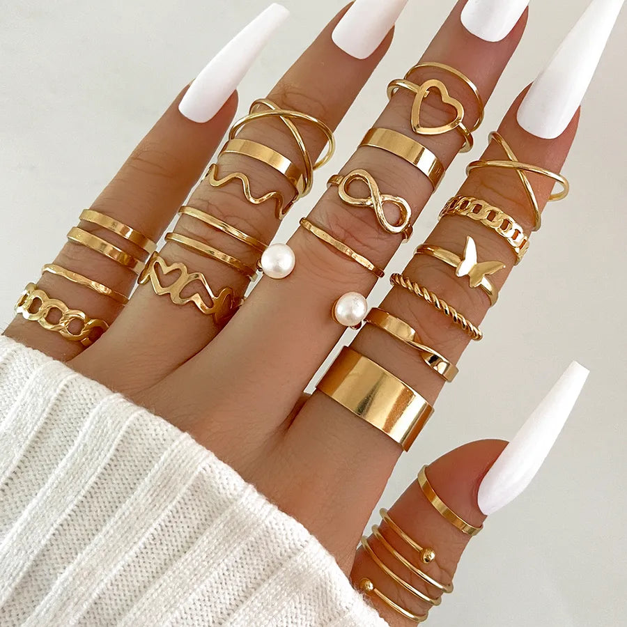 Woman wearing multiple gold-tone retro rings with pearl accents