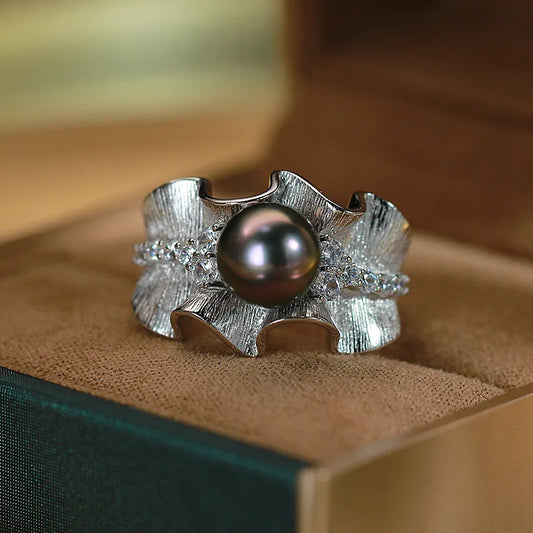 Front view of luxury silver-tone wave ring with black pearl and crystal accents in jewelry box